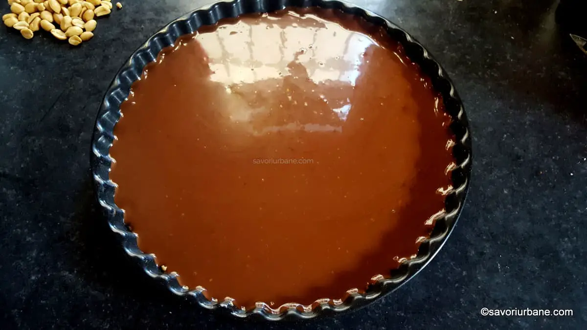 cum se face stratul de ganache de ciocolata amaruie pentru tarta snickers fara coacere (2)