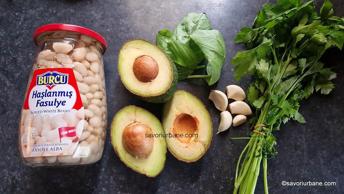 Ingrediente pentru pastă de avocado cu fasole, usturoi, busuioc și limetă sau lămâie